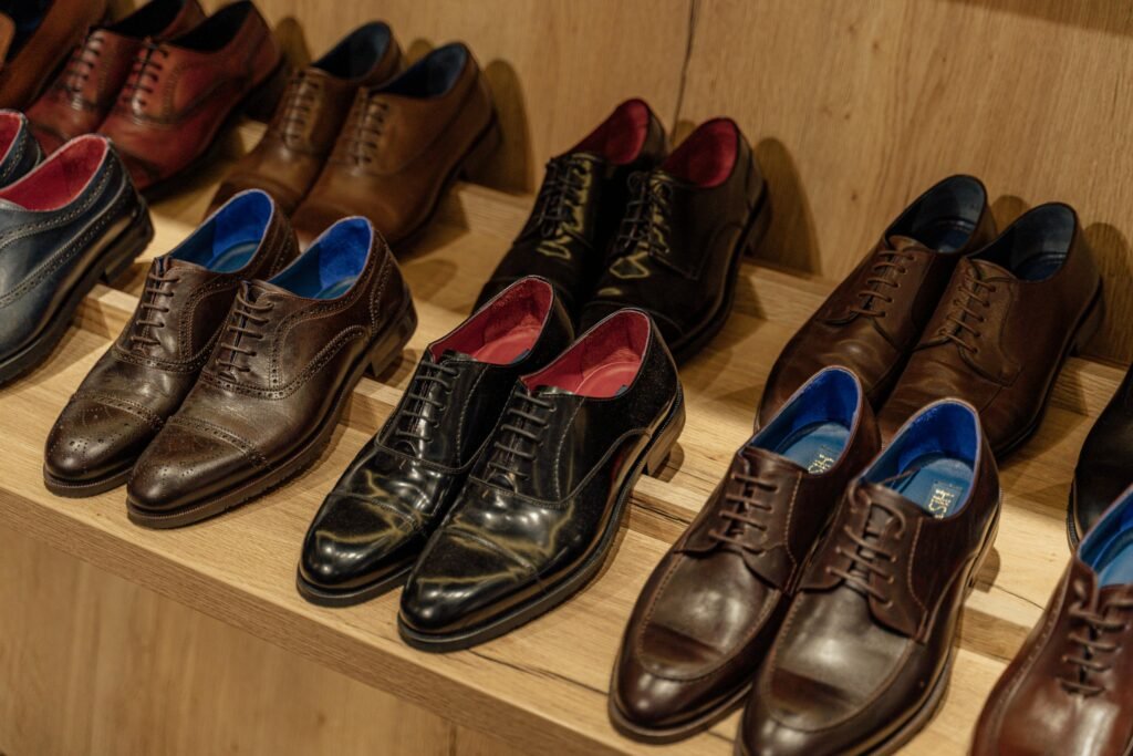 Showcase of elegant leather dress shoes on wooden shelves in-store display.